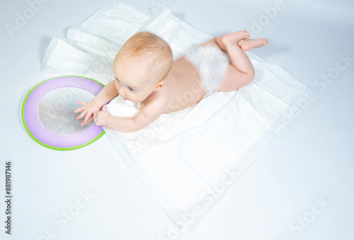 Obraz na płótnie a baby with a mirror lies on a white background. banner with a copy space. w salonie