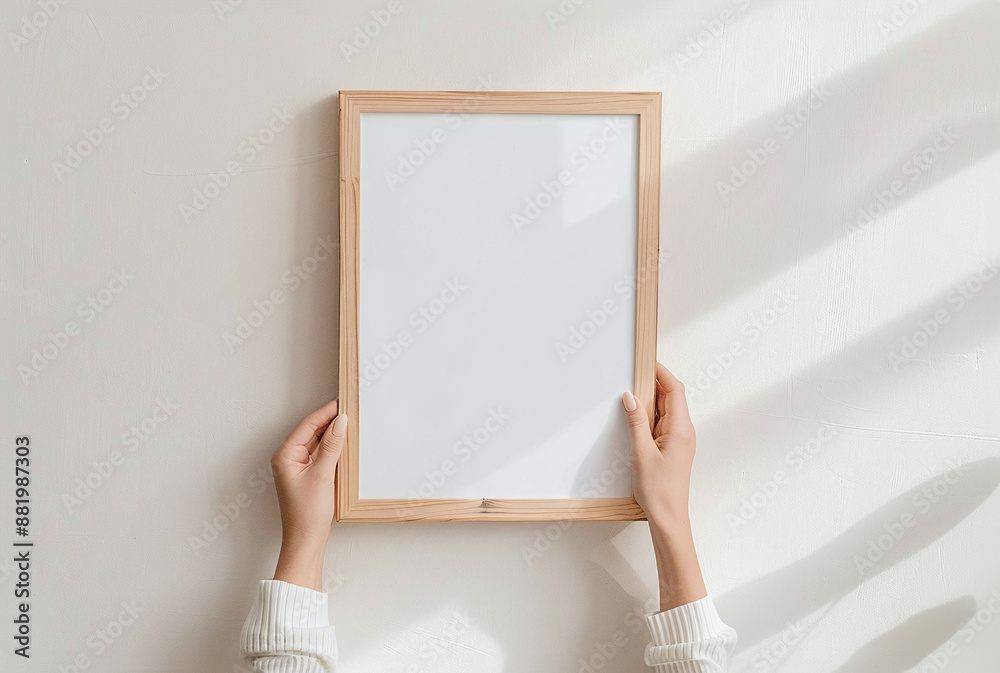 Wooden blank vertical frame in hands of woman. Minimalistic frame mockup for prints and poster. Wooden blank vertical frame in hands of woman. Minimalistic frame mockup for prints and poster.