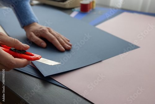 High-quality image of a person binding a book using traditional coptic stitch technique. DIY bookbinding, handcrafting, artisan book, handmade, coptic stitch, binding tools, creative, detailed process photo