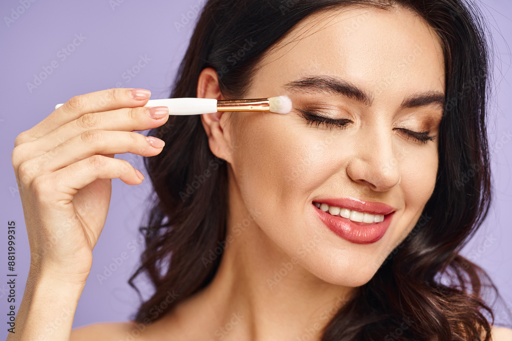 A woman delicately applies eyeshadow with a makeup brush. A woman delicately applies eyeshadow with a makeup brush.