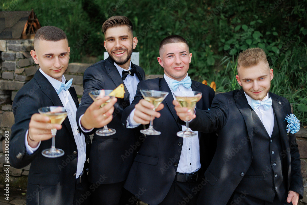 A group of men in suits are holding up glasses of champagne and smiling. Scene is celebratory and happy A group of men in suits are holding up glasses of champagne and smiling. Scene is celebratory and happy