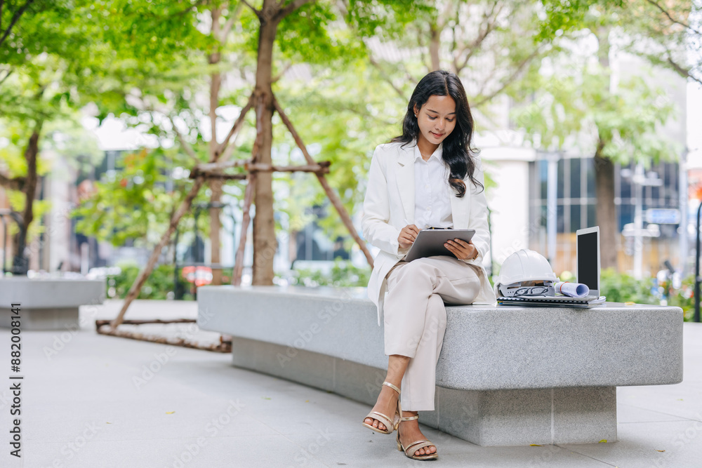 Smart young engineer using tablet sketch design at green park nature. Environmental saving energy project designer working women .