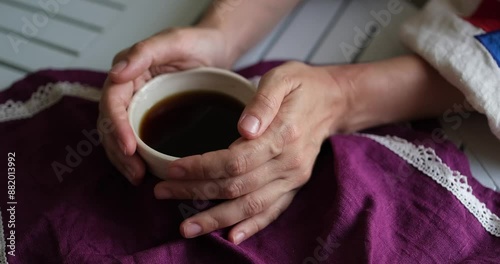 Female hand on the white table with ceramic cup of coffee. Rest relax concept. Vintage village mood. Close up. video footage 4k