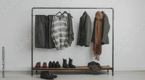 Brown and White Striped Scarf Hanging on Gray Coat in a Modern Closet