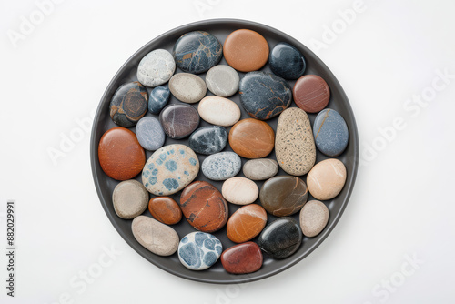 A collection of colorful, smooth pebbles arranged neatly on a white background, showcasing a variety of natural stones and textures.