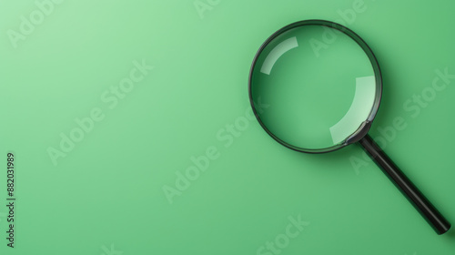 Closeup of a black magnifying glass on a vibrant green background, symbolizing research, investigation, and detail-oriented processes. photo