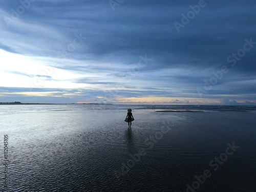 silhueta de mulher com chapéu e saia no nascer do sol em barra do mundaú, ceará  photo