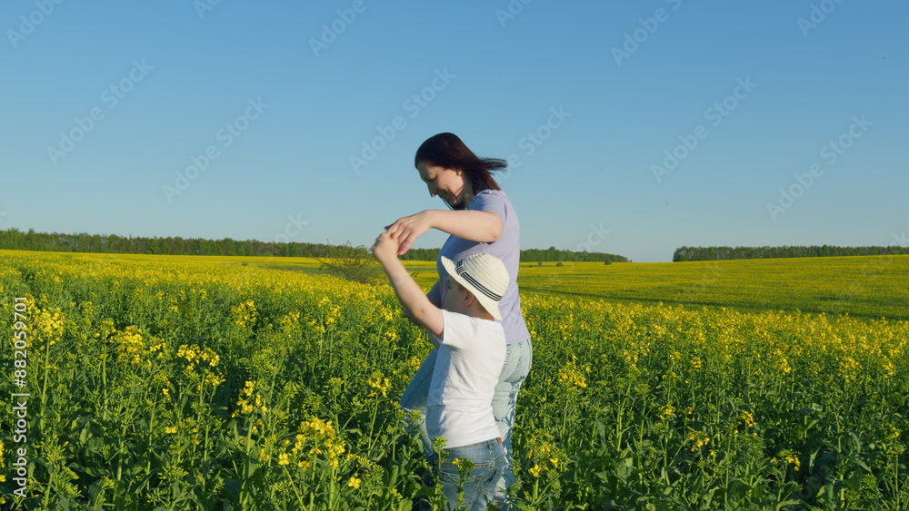 Farmer Family Scene Of Mom And Son Boy Inspect Rapeseed Crop. A Happy Family. Rapeseed Field. Harvest. Agricultural Business. Farmer Family Scene Of Mom And Son Boy Inspect Rapeseed Crop. A Happy Family. Rapeseed Field. Harvest. Agricultural Business.