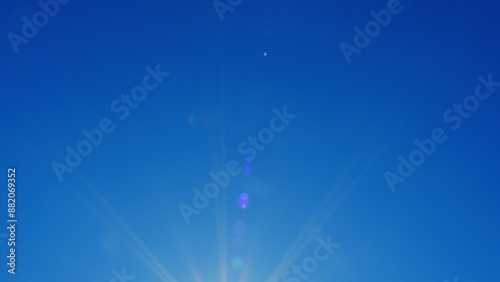 Bright Shining Sun In A Blue Sky No Clouds. Sunbeams And Flares Shining On Sunny Clear Blue Sky Background In Tropical Summer. Sunny Day.