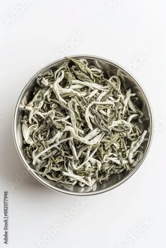 A metal bowl filled with white and green tea leaves