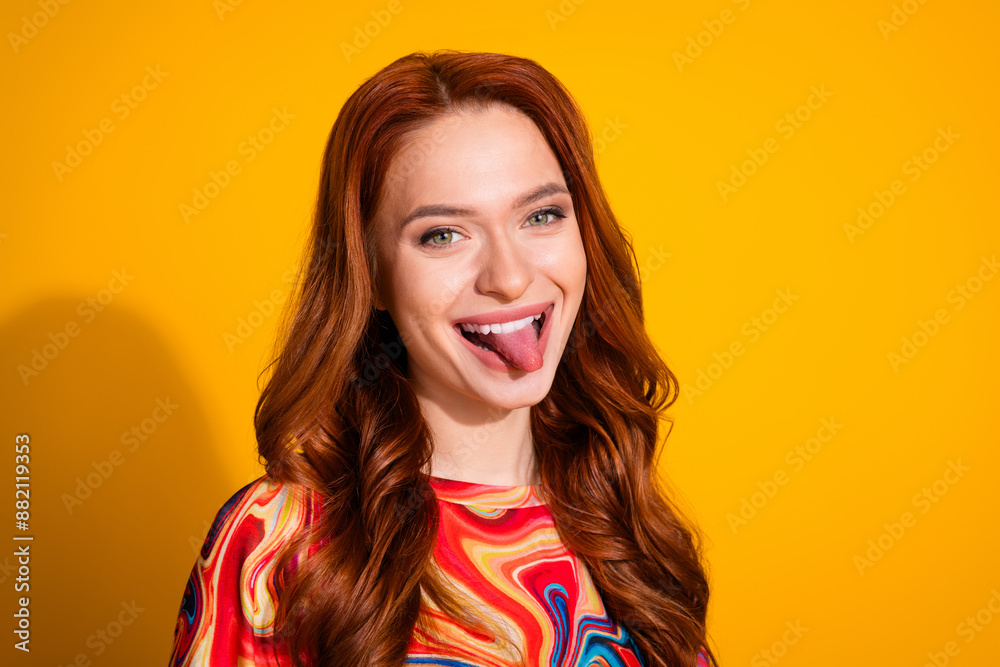Photo portrait of lovely young lady stick tongue out dressed stylish colorful garment isolated on orange color background Photo portrait of lovely young lady stick tongue out dressed stylish colorful garment isolated on orange color background