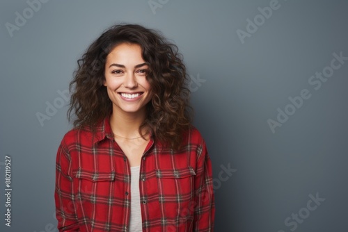 Portrait of a cheerful woman in her 30s dressed in a relaxed flannel shirt isolated on blank studio backdrop © Markus Schröder
