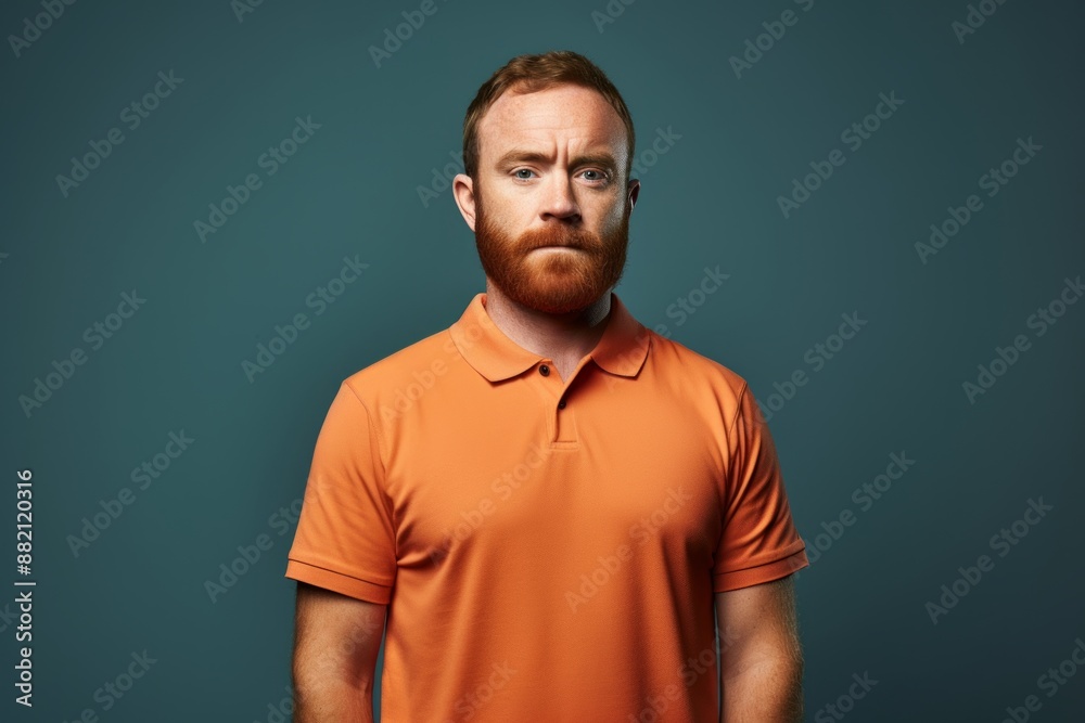 Portrait of a content man in his 30s wearing a breathable golf polo in front of blank studio backdrop Portrait of a content man in his 30s wearing a breathable golf polo in front of blank studio backdrop