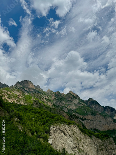 Sharp peaks of the Caucasus mountains against the background of a cloudy sky in Vladikavkaz, Russia photo