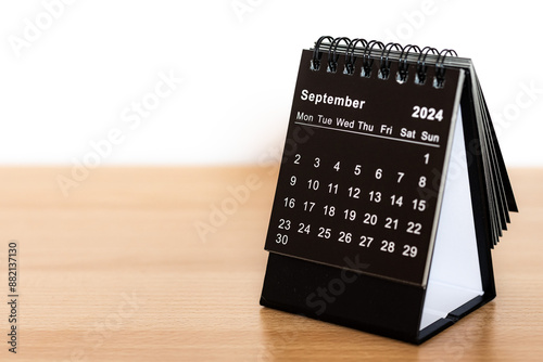 Foto September 2024 black calendar - month page on the wooden desk