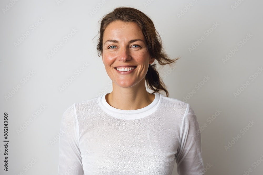 Portrait of a smiling woman in her 30s sporting a long-sleeved thermal undershirt in plain white digital canvas