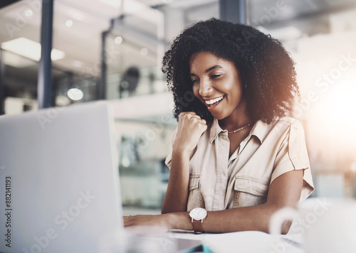 Woman, happy and fist or office with laptop, business email and online confirmation for company deal success. Smile, good news and winner for work bonus, web design and project approval in workplace photo