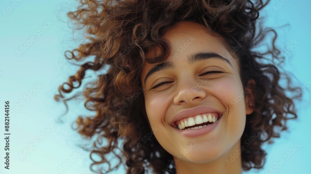 Beautiful smiling girl with a voluminous curly hairstyle, captured with natural lighting and a clean background Beautiful smiling girl with a voluminous curly hairstyle, captured with natural lighting and a clean background