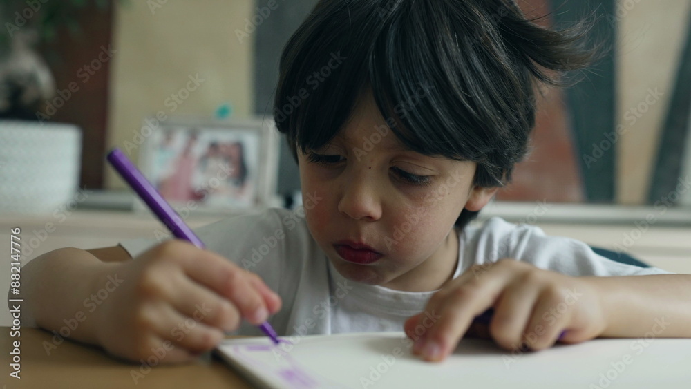 Child focused on drawing with a purple marker, face and hand in view, capturing the moment of creativity in a comfortable home environment, highlighting concentration and artistic expression Child focused on drawing with a purple marker, face and hand in view, capturing the moment of creativity in a comfortable home environment, highlighting concentration and artistic expression