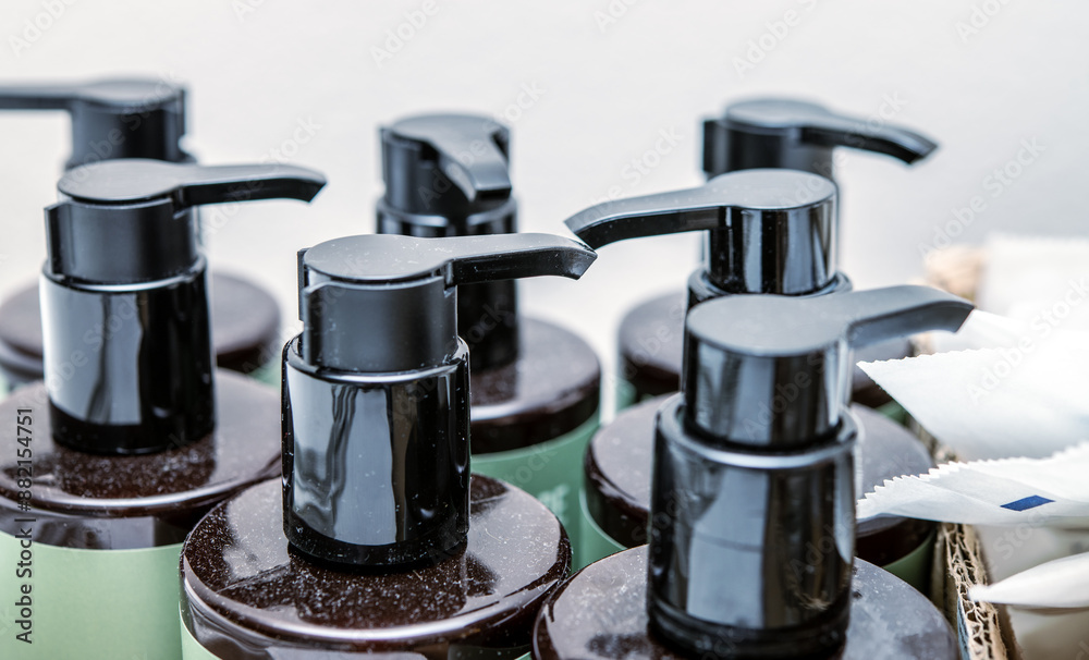 Close-up of Multiple Black Pump Dispenser Bottles in Bathroom, Water Drops Detail, Health and Beauty Packaging Concept Close-up of Multiple Black Pump Dispenser Bottles in Bathroom, Water Drops Detail, Health and Beauty Packaging Concept