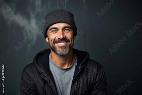 Portrait of a happy man in his 40s sporting a trendy beanie on plain cyclorama studio wall