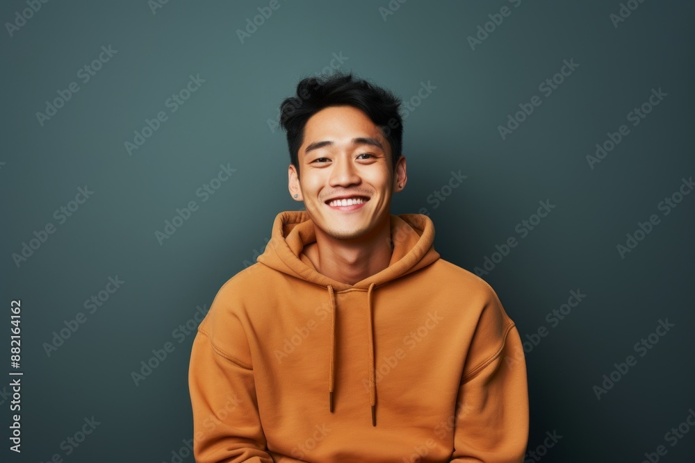 Portrait of a happy asian man in his 20s wearing a thermal fleece pullover over plain cyclorama studio wall Portrait of a happy asian man in his 20s wearing a thermal fleece pullover over plain cyclorama studio wall
