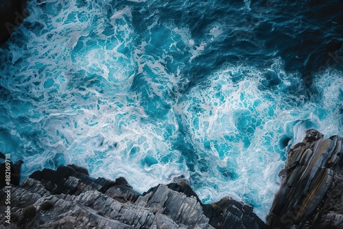 topdown breathtaking shot of a pristine ocean meeting a rugged rocky shoreline highlighting natures raw beauty and power in a visually stunning composition © furyon