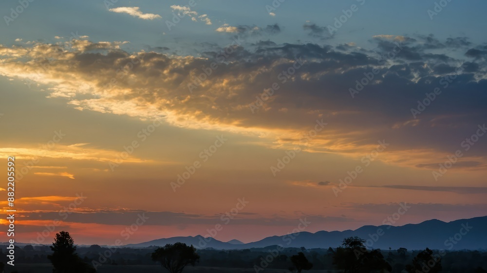 Fototapeta premium A serene sunset landscape with silhouetted mountains and a colorful sky, perfect for nature concepts, calm evening scenes, and scenic beauty