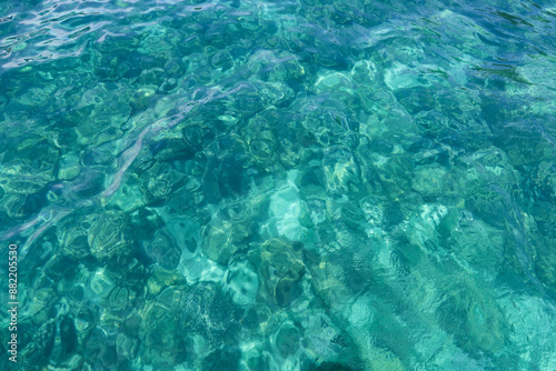 Blue water with ripples on the surface. Defocus blurred transparent blue colored clear calm water surface texture with splashes and bubbles. Water waves with shining pattern texture background.