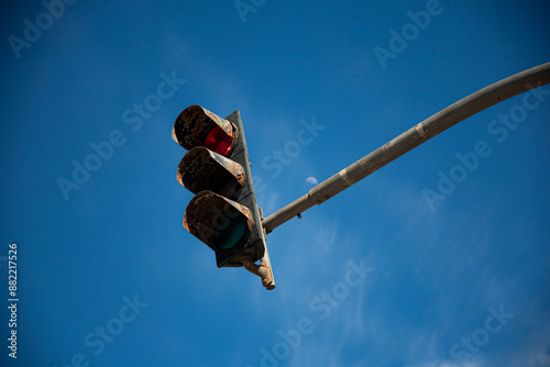 blue sky with a rusty red traffic light