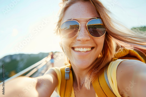 Happy girl is traveling in nature on beautiful summer day. Young woman blogger taking selfie, streaming online, recording videos with her smartphone. Summer, vacation, solo travel, holiday, trip