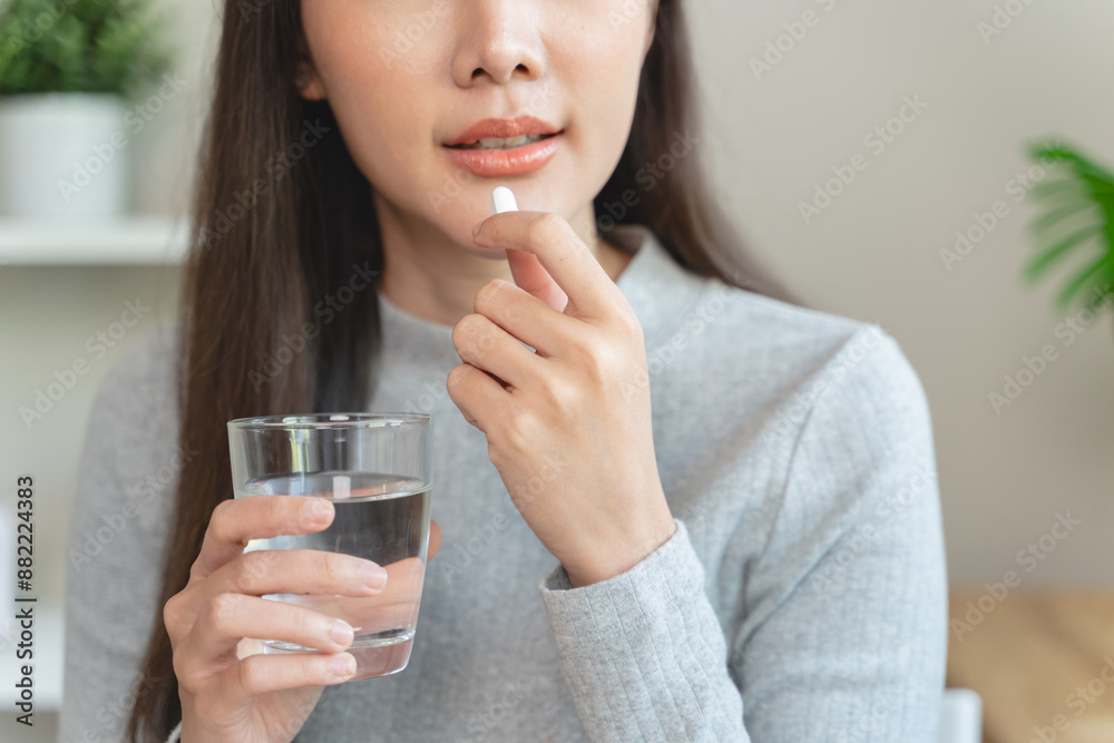 Dietary supplement, asian young woman, girl hand holding orange medical pill, take or eat vitamin C, D for treatment for skin Dietary supplement, asian young woman, girl hand holding orange medical pill, take or eat vitamin C, D for treatment for skin