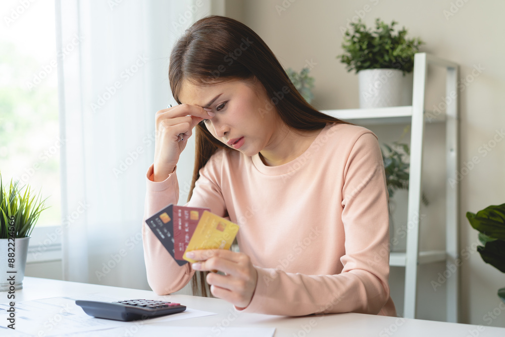 Debt and finance loan concept, Stressed woman holding a mock-up credit card and has an anxious facial expression. Debt and finance loan concept, Stressed woman holding a mock-up credit card and has an anxious facial expression.