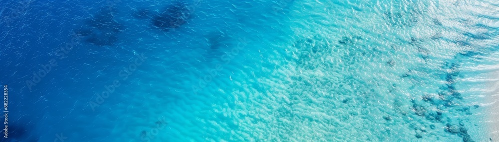 Aerial view of clear turquoise ocean water with sunlight reflections and sandy shallows, creating a serene coastal scene. Aerial view of clear turquoise ocean water with sunlight reflections and sandy shallows, creating a serene coastal scene.