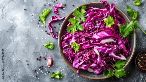  A red cabbage bowl sits atop a table, accompanied by a smaller bowl of seasonings as garnish photo