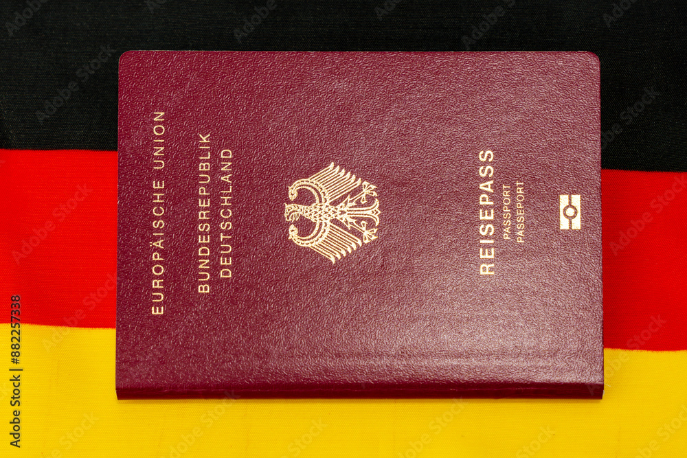Passport with the inscription Reisepass. German citizen passport. It is located on top of the German flag. Passport with the inscription Reisepass. German citizen passport. It is located on top of the German flag.