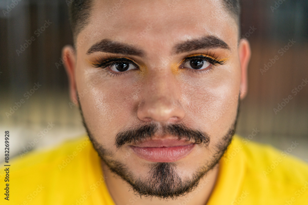 Fototapeta premium Young LGBT male with beard staring at camera