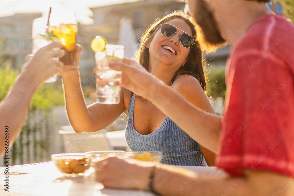 Joyful woman toasts with friends at sunset outdoor party: Carefree summer social gathering - essence of carefree summer socializing with friends. Joyful woman toasts with friends at sunset outdoor party: Carefree summer social gathering - essence of carefree summer socializing with friends.