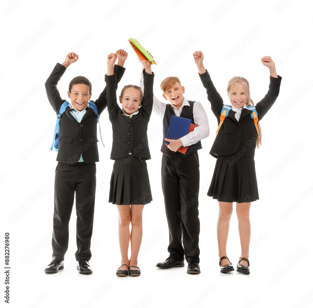 Little classmates in stylish uniform with backpacks and notebooks on white background Little classmates in stylish uniform with backpacks and notebooks on white background