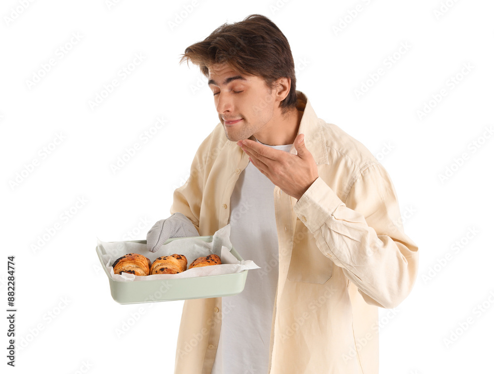 Handsome young man holding baking dish with fresh croissants on white background Handsome young man holding baking dish with fresh croissants on white background