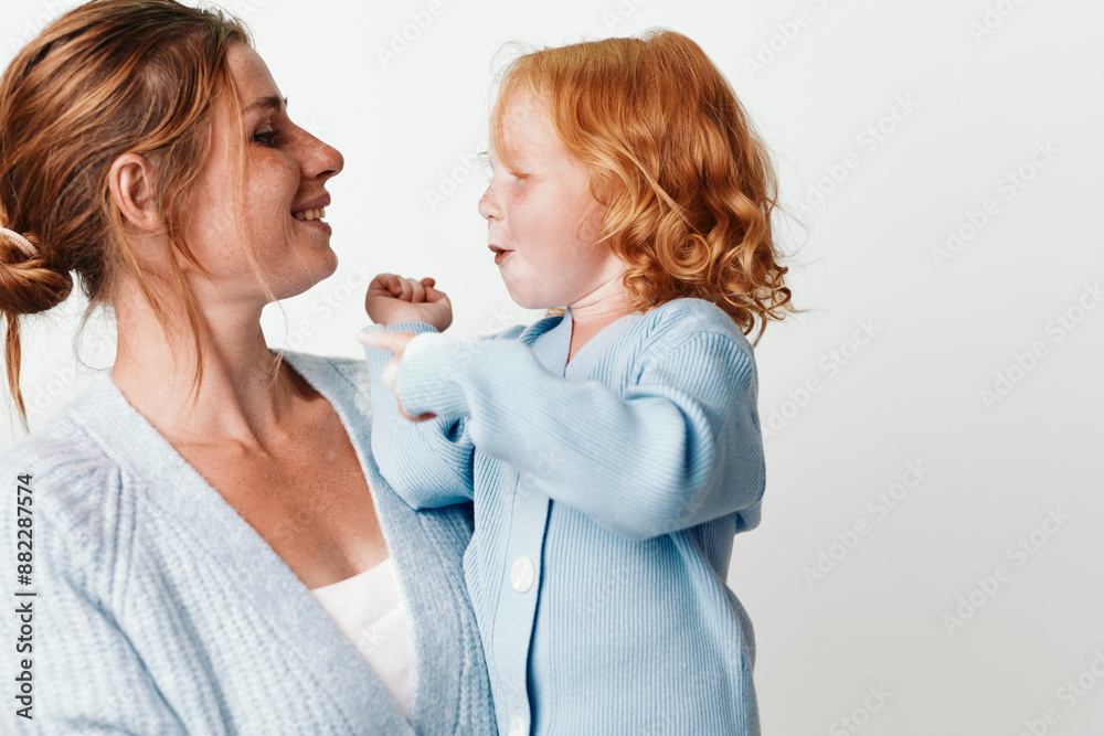 Happy mother holding smiling daughter in arms, family fun and love, childhood joy and happiness Happy mother holding smiling daughter in arms, family fun and love, childhood joy and happiness