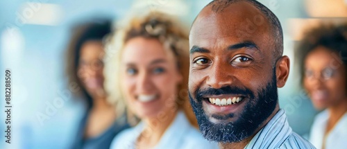 A close-up view showcases diverse colleagues working together in a modern office. Warm smiles and focused expressions highlight a positive and collaborative environment.