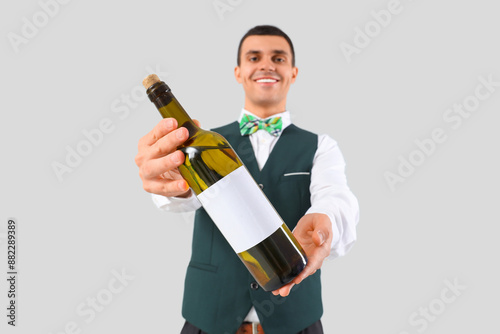 Young barman with bottle of...