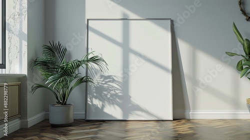 An empty canvas positioned against a well-lit wall, accompanied by a shadowed indoor plant, with the wooden floor casting subtle reflections, creating a modern space.