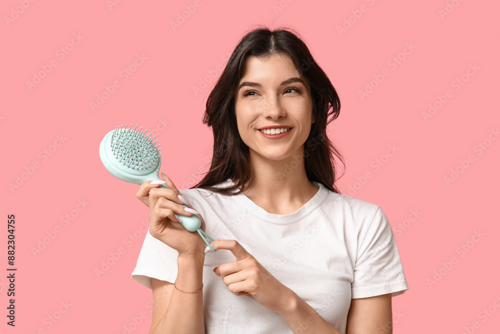 Beautiful young woman with blue hair brush on pink background Beautiful young woman with blue hair brush on pink background