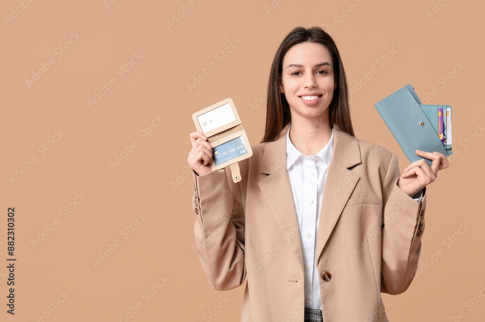 Beautiful woman with credit card holders and wallet on brown background Beautiful woman with credit card holders and wallet on brown background