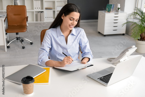 Pretty businesswoman writin...