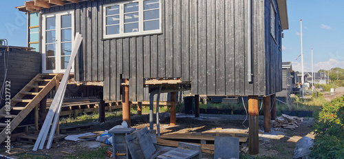 Danish summer houses or holiday homes by the sea have been raised up on pillars to avoid flooding due to climate and weather changes with more rain coming