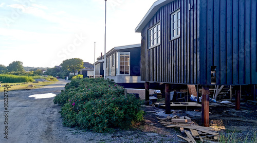 Danish summer houses or holiday homes by the sea have been raised up on pillars to avoid flooding due to climate and weather changes with more rain coming