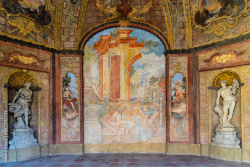 The Sala Terrena in Prague Vrtba Garden features intricate murals and sculptures. The main mural depicts a scene with figures in classical attire, while the walls are adorned with additional paintings photo